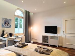 a bedroom with a bed and a desk and a tv at ApartZ - Celle - CityQuartier - bis 15 Personen - 4 Apartments in Celle