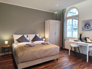 a bedroom with a bed and a desk and a window at ApartZ - Celle - CityQuartier - bis 15 Personen - 4 Apartments in Celle