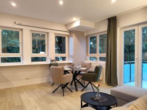 a living room with a table and chairs and windows at ApartZ - Celle - CityQuartier - bis 15 Personen - 4 Apartments in Celle