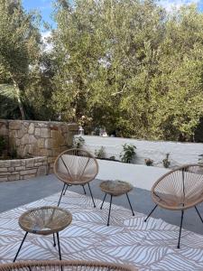 a group of three chairs and tables on a rug at Olive Grove Retreat Paxos in Vlachopoulátika