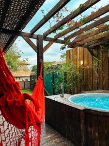 a hammock is hanging next to a swimming pool at Sheeps Family - Loft, Casa e Apartamento para Temporada - Praia do Rosa in Praia do Rosa