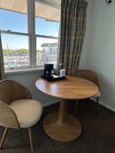 a wooden table with two chairs and a window at The Jetty Motel in Cape May