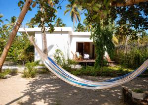 a hammock in front of a house at CosyBe Villas in Praia do Tofo