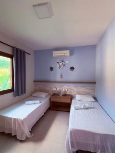 two beds in a room with blue walls at Maruá - Brisa e Sossego em Touros in Touros