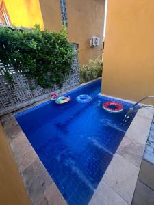 a swimming pool with three inflatable tubes in the water at Maruá - Brisa e Sossego em Touros in Touros