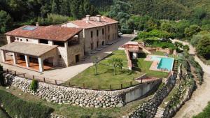 an aerial view of a house with a stone wall at Masia de Can Roig in Riells