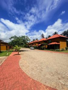 a brick road with a tree in front of a building at Maruá - Brisa e Sossego em Touros in Touros
