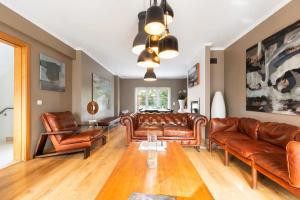 a living room with leather couches and a table at Exquisite Townhouse in Lisbon City Center- PRIVATE GARAGE & TERRACE in Lisbon