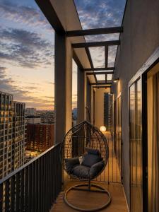 a rattan chair on the balcony of a building at Belgrade Waterfront Penthouse 17th last floor in Belgrade