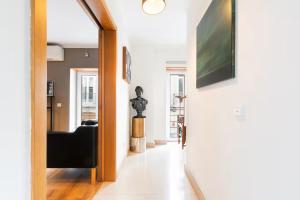 a hallway with a black couch and a television on a wall at Exquisite Townhouse in Lisbon City Center- PRIVATE GARAGE & TERRACE in Lisbon +34 photos