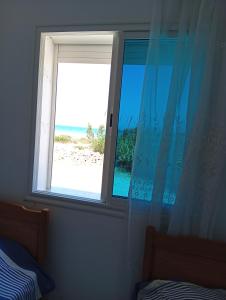 a window of a bedroom with a view of the beach at B Résidence in Salakta