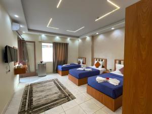 a hotel room with three beds and a flat screen tv at Garden El Tahrir Downtown Hotel in Cairo