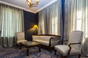 a living room with a couch and two chairs and a table at Hotel Astoria Tbilisi in Tbilisi City