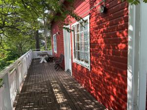 a red house with a wooden porch with a window at HimosKukkula, 140m2 in Jämsä