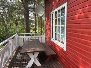 a wooden picnic table on the back porch of a red house at HimosKukkula, 140m2 in Jämsä +59 photos