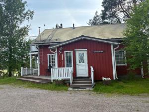 a red tiny house with a white door and stairs at HimosKukkula, 140m2 in Jämsä
