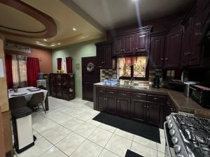 a large kitchen with wooden cabinets and a table at Casa Playa Cieneguita in Puerto Cortés