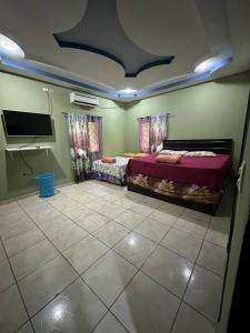 a bedroom with two beds and a flat screen tv at Casa Playa Cieneguita in Puerto Cortés +37 photos