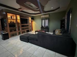 a living room with a couch and a tv at Casa Playa Cieneguita in Puerto Cortés