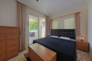 a bedroom with a bed and a dresser and a window at Private Pool Villa with Garden & Forest View in Fethiye +45 photos