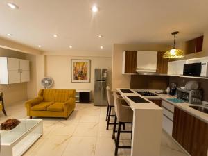 a kitchen and living room with a yellow chair in it at Hospedaje & Minidepas VALERY in Trujillo +38 photos