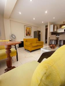 a living room with a yellow couch and a table at Hospedaje & Minidepas VALERY in Trujillo
