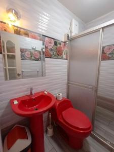 a red sink and a red toilet in a bathroom at Hospedaje & Minidepas VALERY in Trujillo