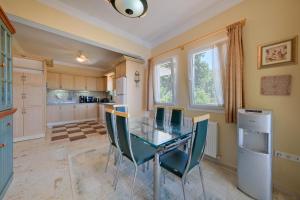 a kitchen with a glass table and chairs at Private Pool Villa with Garden & Forest View in Fethiye