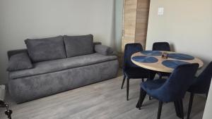 a living room with a couch and a table and chairs at Pokoje "Pod ósemką Mielno" in Mielno