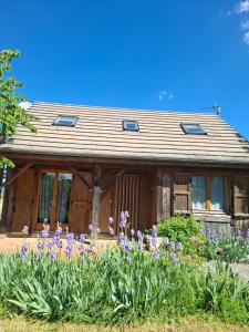 a house with purple flowers in front of it at Isa's Little Cottage in Saint-Bonnet-de-Chirac