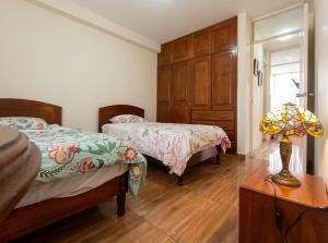 a bedroom with two beds and a lamp on a table at Hospedaje & Minidepas VALERY in Trujillo