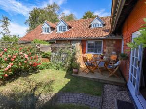 a small yard with a table and chairs in front of a house at Gables Cottage in Market Rasen