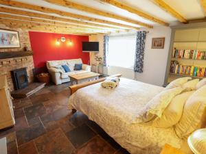 a bedroom with a large bed and a living room at Gables Cottage in Market Rasen