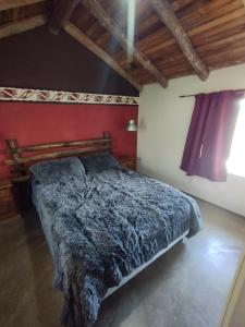 a bedroom with a bed with a blue blanket at Cabaña Kokopelli in Villa Giardino
