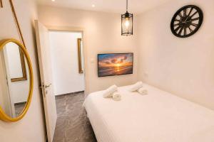 a bedroom with a bed and a clock on the wall at Barak Royal suites VIP 46 - חמש דקות מהים ומהטיילת in Eilat +22 photos