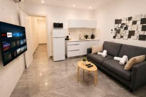 a living room with a couch and a table and a kitchen at Barak Royal suites VIP 46 - חמש דקות מהים ומהטיילת in Eilat
