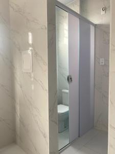 a bathroom with a toilet and a glass door at APTO - Espaço Vix II in Vitória +20 photos