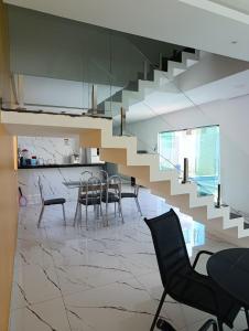 a dining room with chairs and a staircase in a house at Pousada Natural Hostel in Maragogi