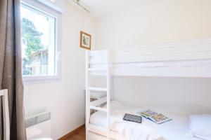 a bedroom with a bunk bed and a window at Résidence Pierre & Vacances Les Cottages Du Lac in Parentis-en-Born