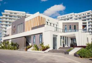 a white building in front of a large building at Caesar Blue Studio Sea View Apartment in Boghaz