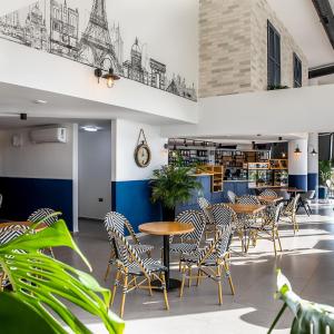 a restaurant with tables and chairs in a building at Caesar Blue Studio Sea View Apartment in Boghaz