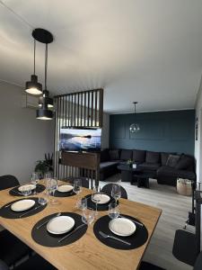 a dining room table with plates and wine glasses at Nordlys Skaland in Senja