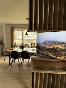 a dining room with a table with chairs and a tv at Nordlys Skaland in Senja