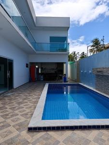 a swimming pool in front of a building at Pousada Natural Hostel in Maragogi