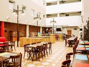 ein Restaurant mit Tischen und Stühlen und einer Cafeteria in der Unterkunft Hotel Ibis Łódź Centrum in Łódź