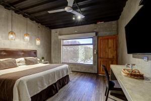 a bedroom with a bed and a large window at Hoteles Pueblo de Tierra in San Pedro de Atacama +76 photos