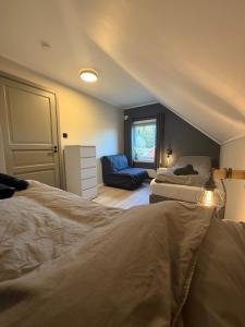 a attic bedroom with two beds and a chair at Nordlys Skaland in Senja