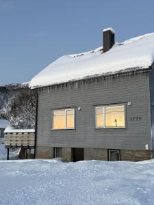 a house with snow on the roof at Nordlys Skaland in Senja