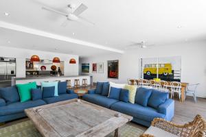a living room with blue couches and a table at Stonecutters 2 in Byron Bay