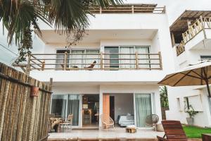 a white house with a balcony and a patio at Casa Mandala - Rooftop com Jacuzzi e Vista Mar in Barra Grande